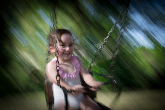 Girl playing on a swing - Photo by Gustavo Devito